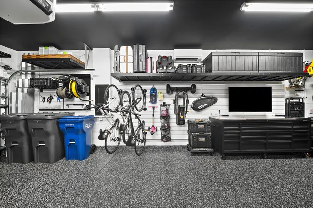 Car care, cycling, and workshop tasks each have a place along one wall, with bulky and seasonal storage kept above.
