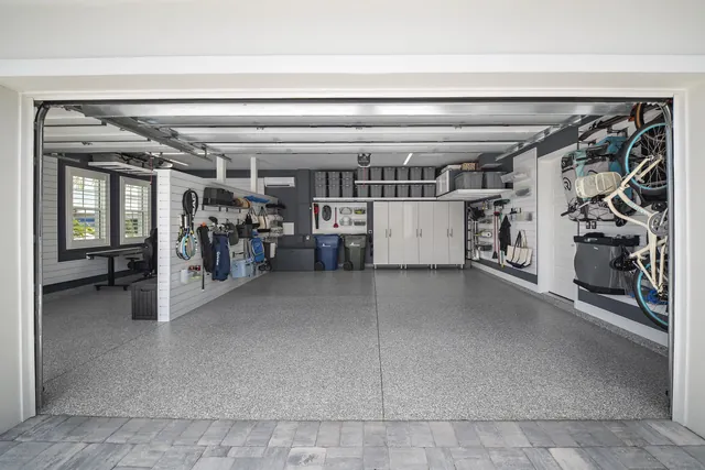 Continuous flooring and coordinated storage make the two-car bay feel like a finished part of the home.