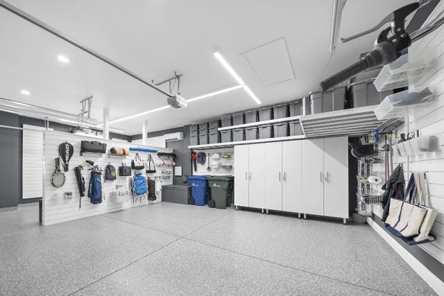 A wide view of the storage bay shows cabinetry, overhead bins, and slatwall arranged around clear floor space.