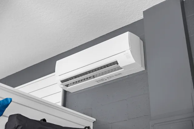 A wall-mounted mini-split above the slatwall partition.