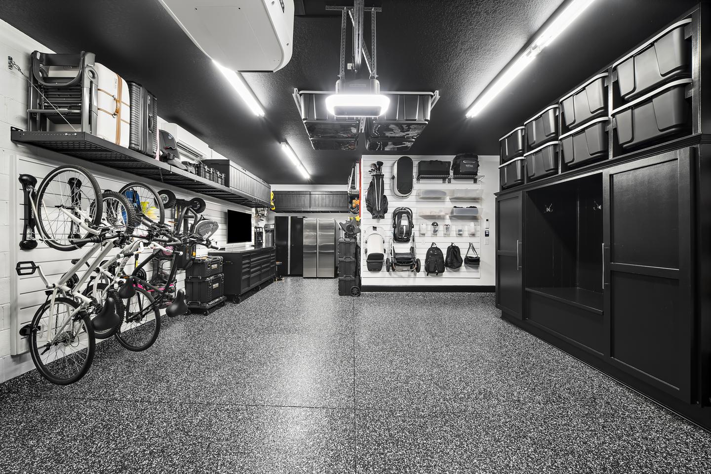 Open workshop floor between bike storage, cabinetry, and wall-mounted family equipment