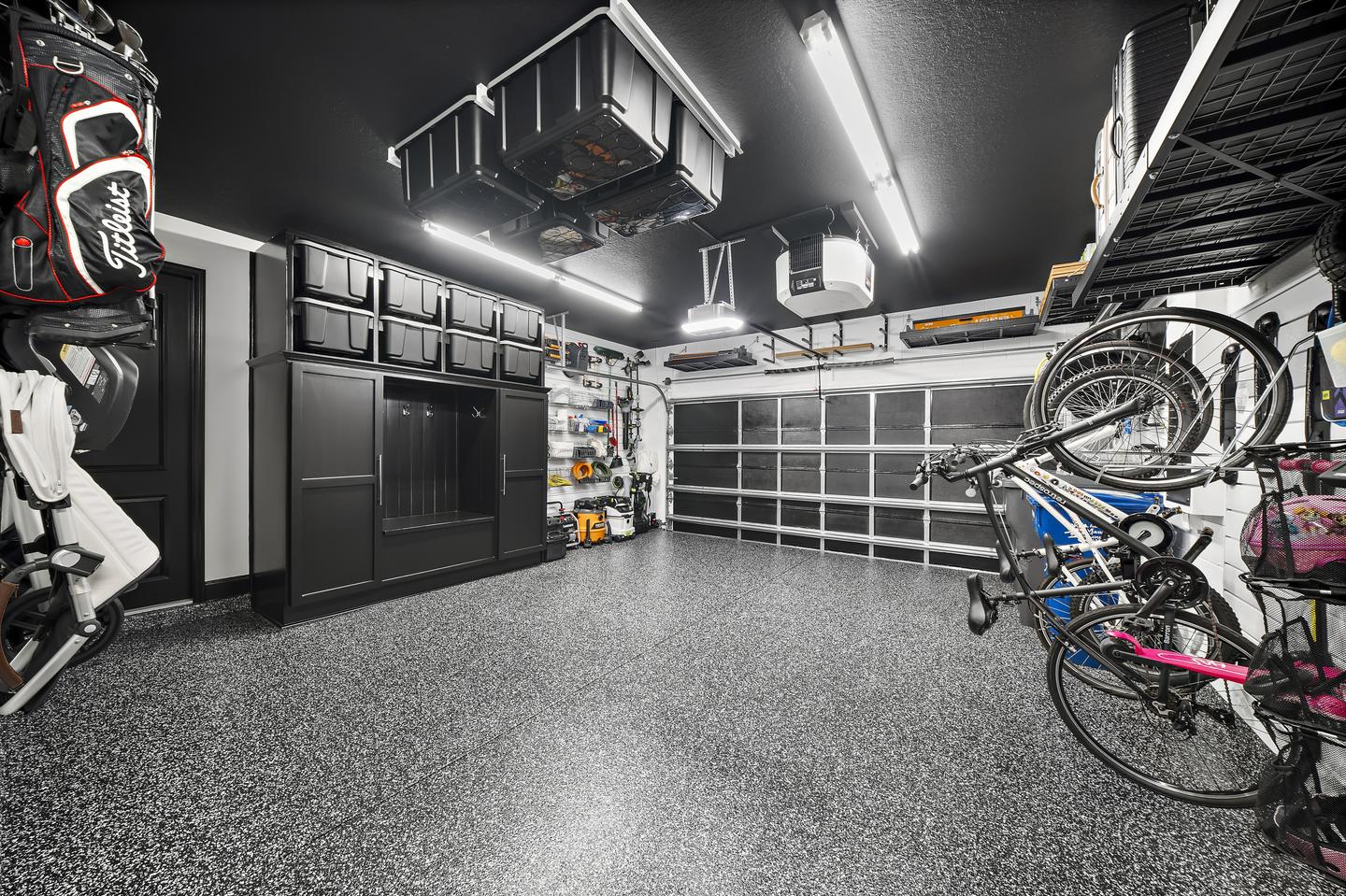 Workshop with clear floor space between cabinetry, bikes, and wall storage
