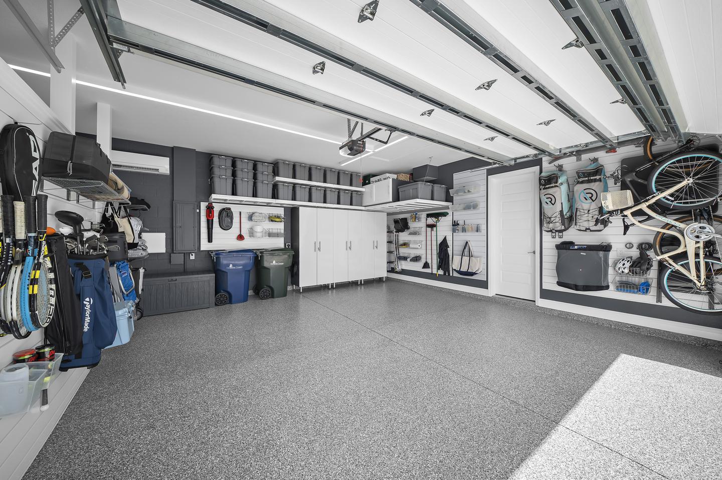 Open two-car bay with coordinated flooring, cabinetry, and perimeter storage