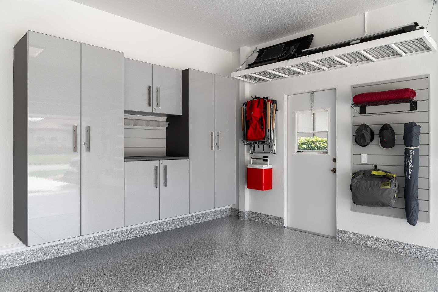 Garage with enclosed cabinets, wall storage, and an open central floor