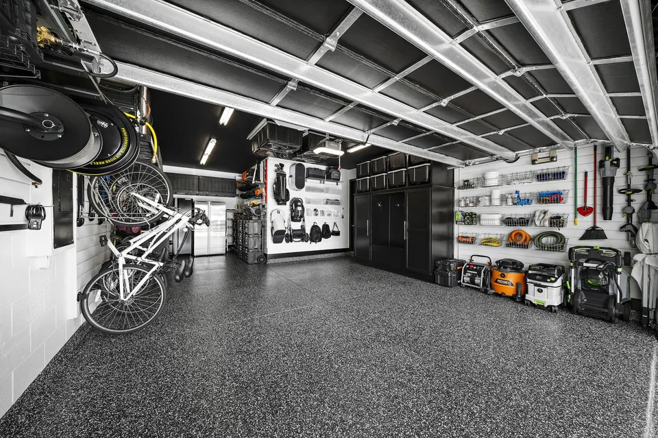 The coated floor connects bike storage, workshop equipment, and enclosed cabinetry across the room.