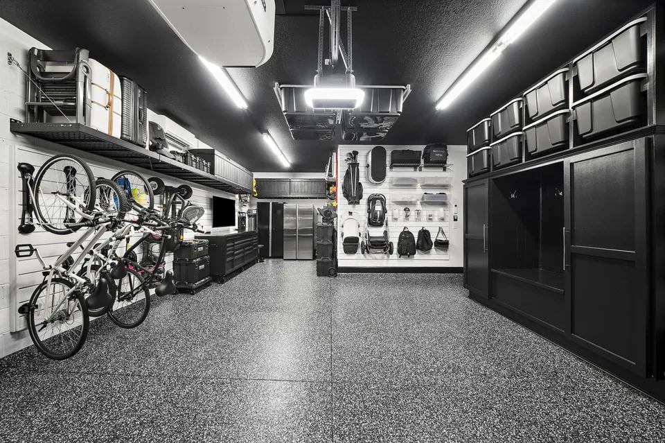 Open workshop floor between bike storage, cabinetry, and wall-mounted family equipment