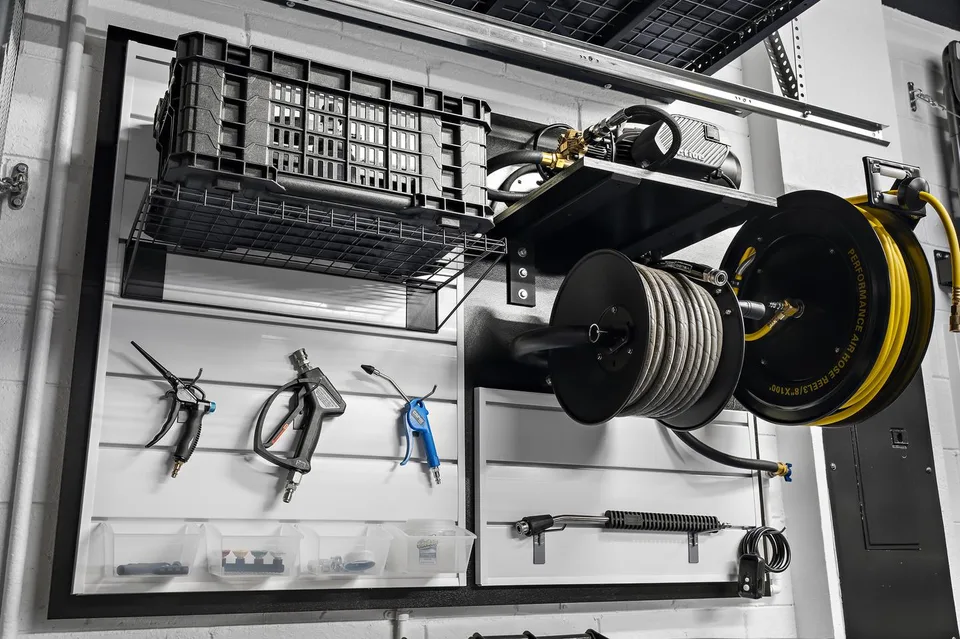 Wall-mounted air and water hose reels with spray tools and detailing accessories.