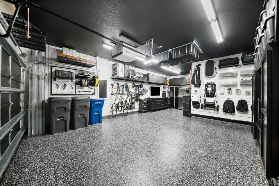 High shelving and overhead bins around the garage perimeter, with wall storage and cabinetry below.