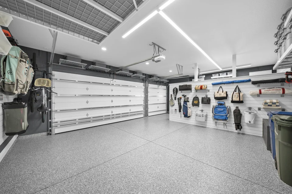 The open two-car bay with storage along the perimeter and the garage doors ahead.