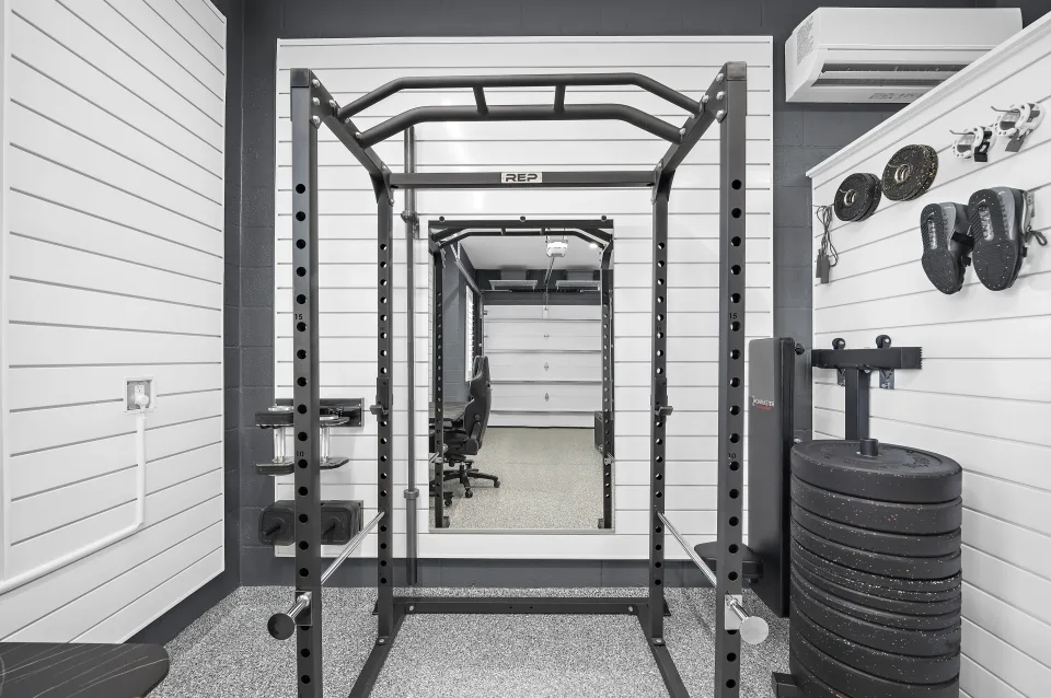 Fitness equipment and a full-height mirror beside the partition, with the mini-split above.