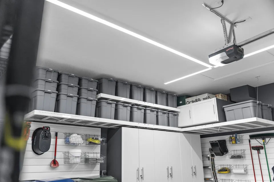 Rows of matching bins sit on overhead shelving above the cabinetry and everyday wall storage.